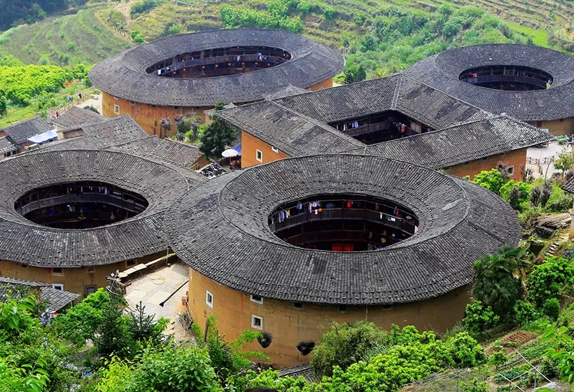 Traditional circular and square Fujian tulou earthen buildings surrounded by green hills
