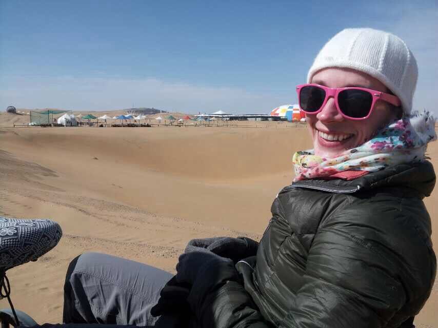 Traveler wearing sunglasses among desert sand dunes