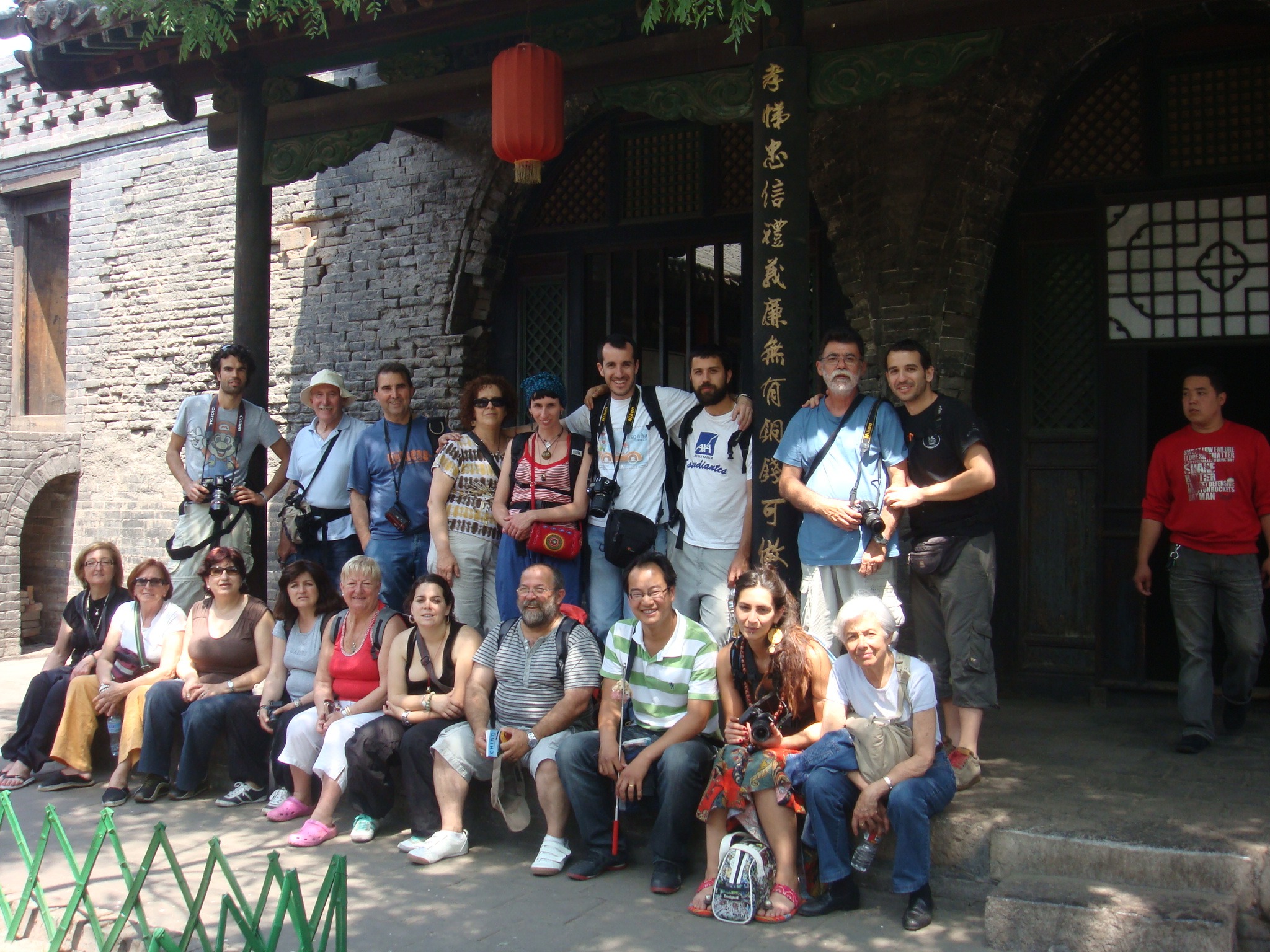 Traveler group posing outside a traditional stone building