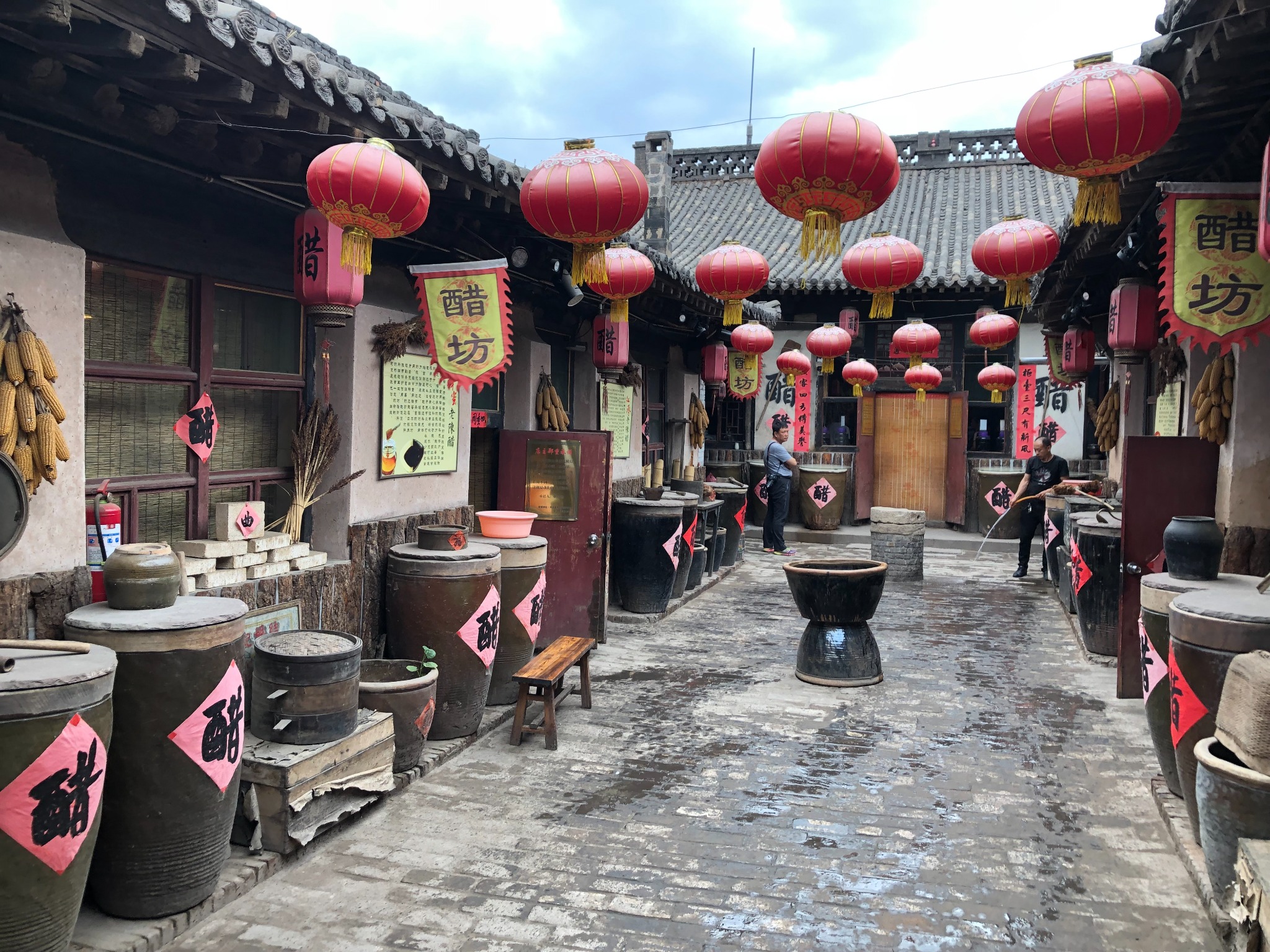 Traditional vinegar-making courtyard with red lanterns and earthenware jars